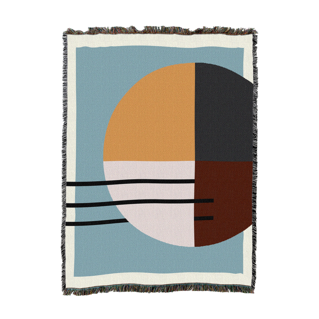 Woven cotton throw with a quartered circle in sand, blush, charcoal and brown on slate blue, shown flat