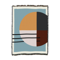 Woven cotton throw with a quartered circle in sand, blush, charcoal and brown on slate blue, shown flat