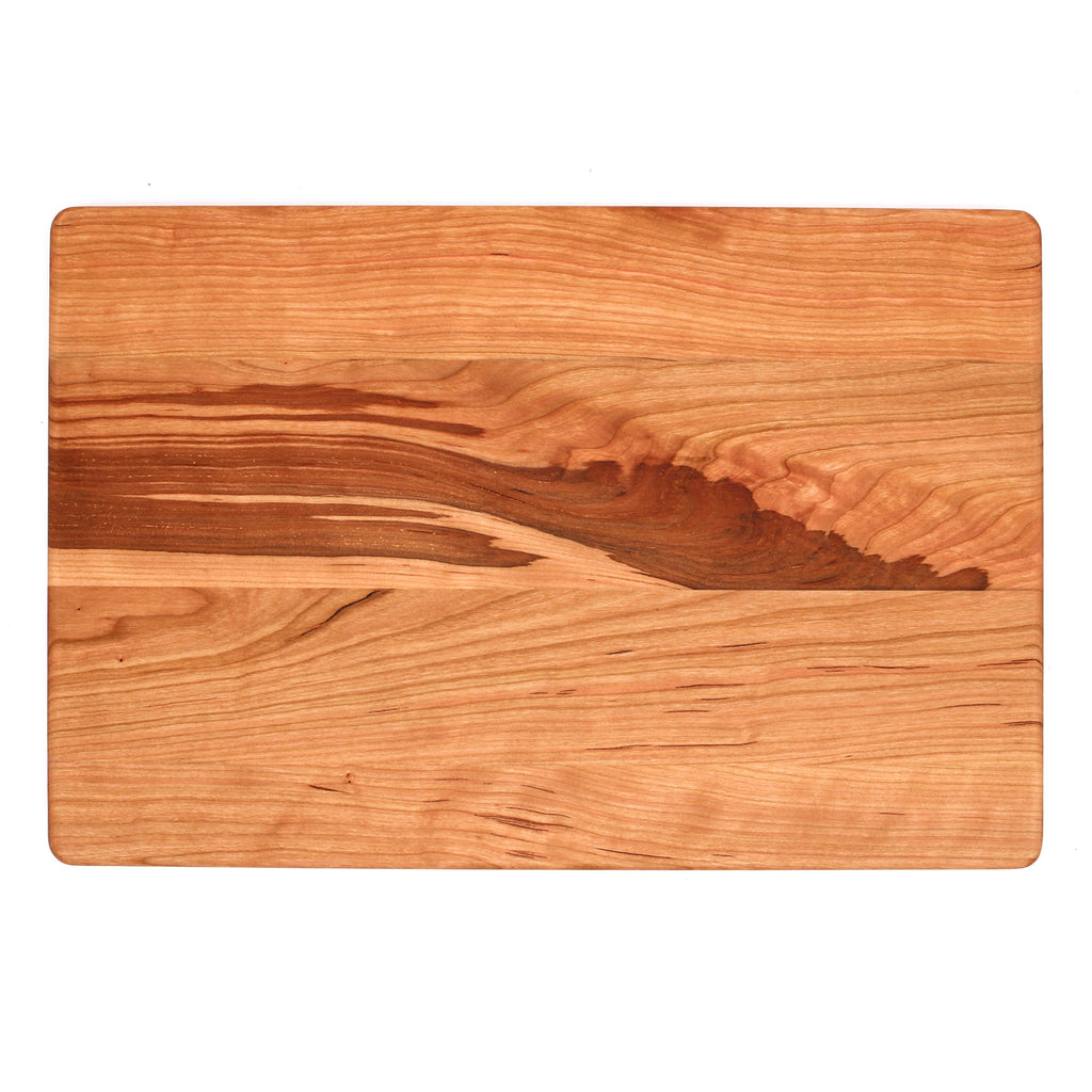 Cherry cutting board, 18 x 12 in, overhead view of the plain face with a dramatic dark grain streak