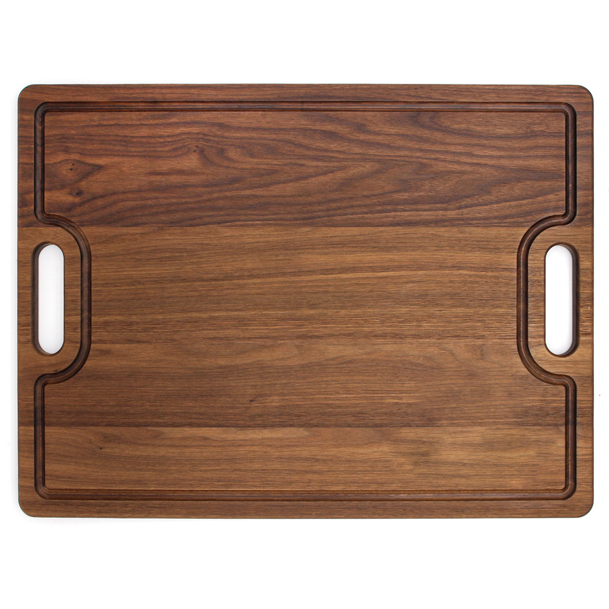 Extra large walnut cutting board with cutout handles and juice groove, 24 x 18 in, overhead view on white