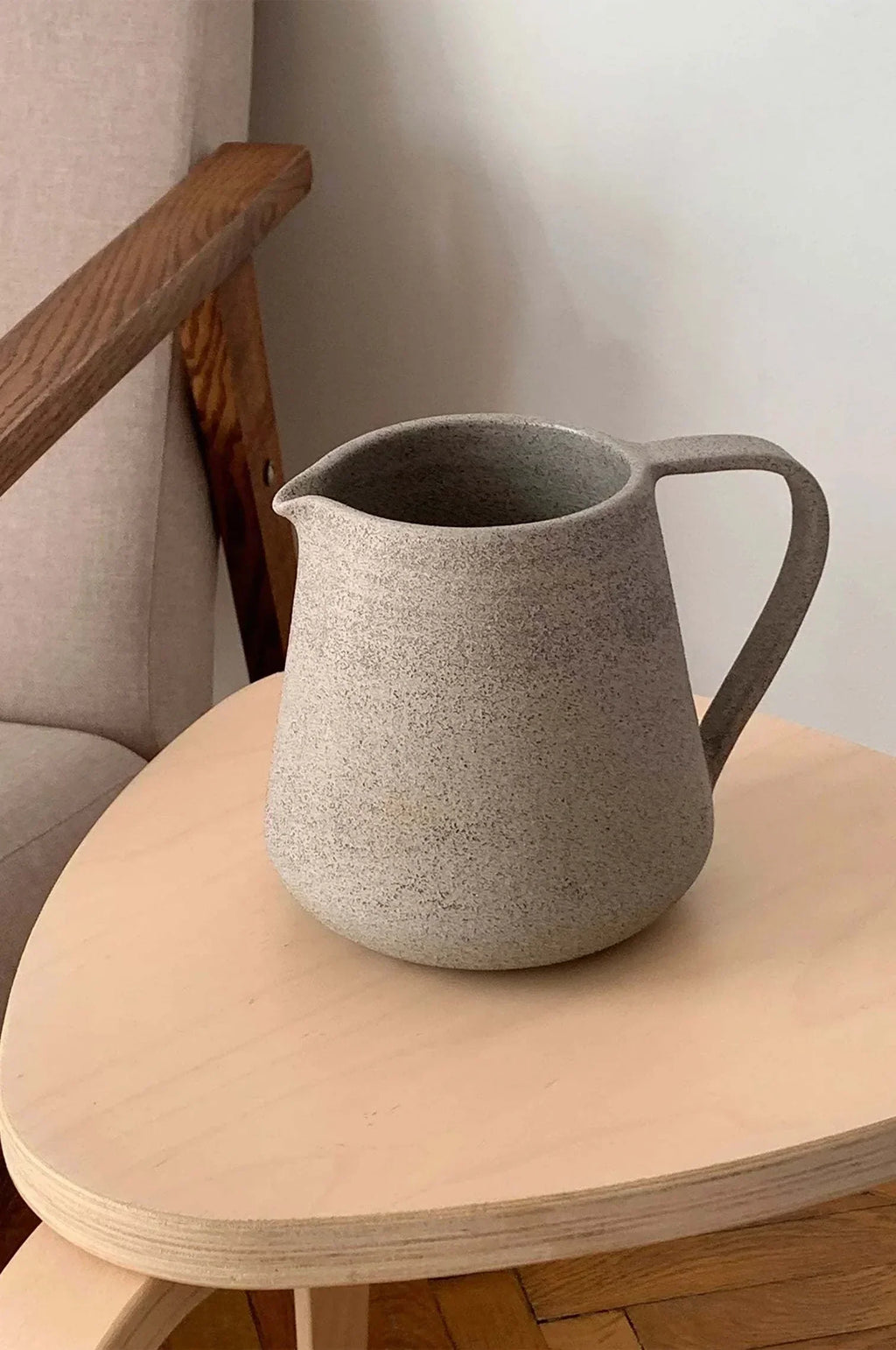 Concrete-Toned Stoneware Pitcher shown from a second angle against a pale neutral backdrop