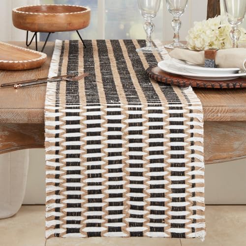 Woven stitch table runner in black and natural draped over the end of a wood dining table set with plates and glasses