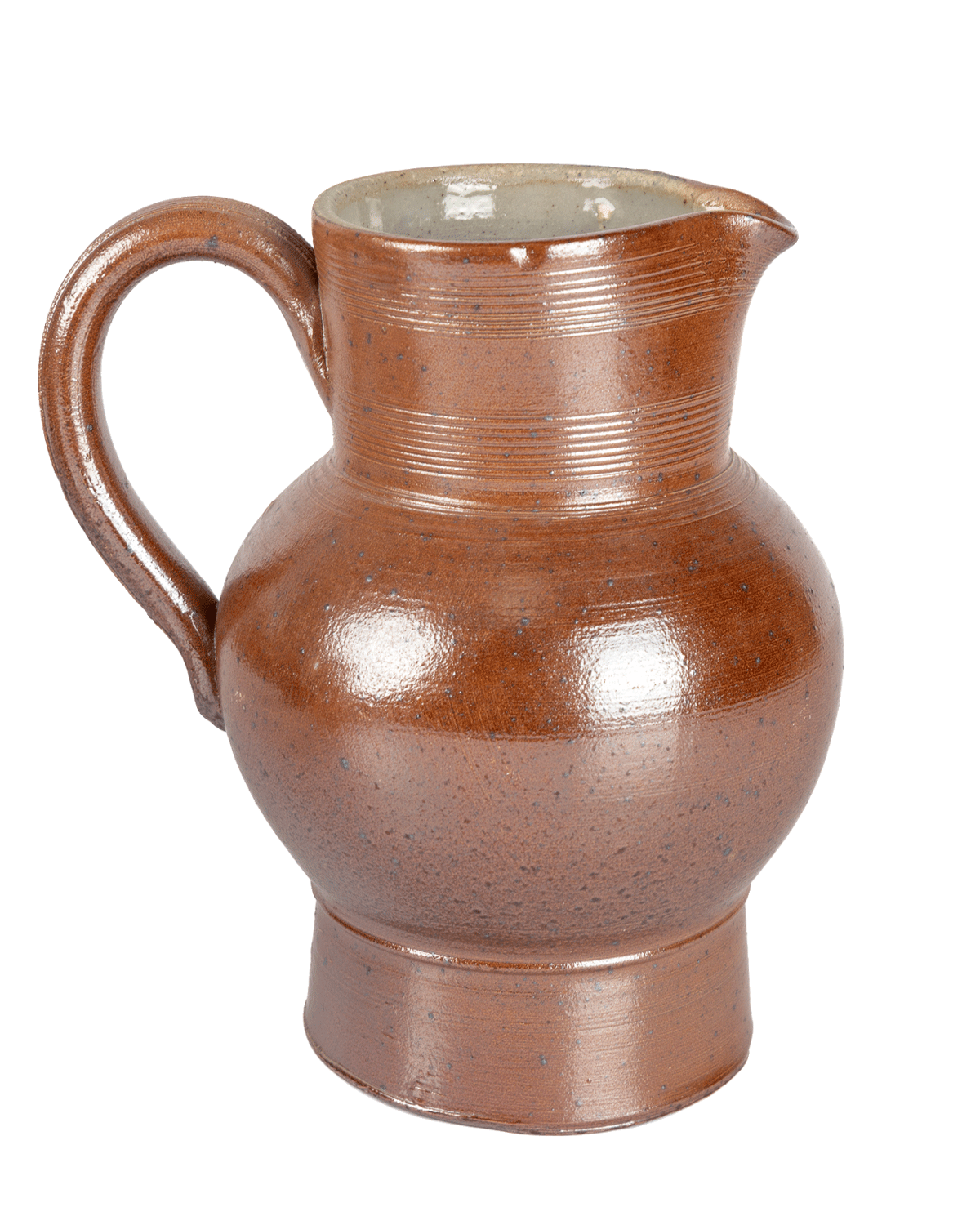 Front view of a speckled brown salt-glazed ceramic pitcher with a light interior on a green background