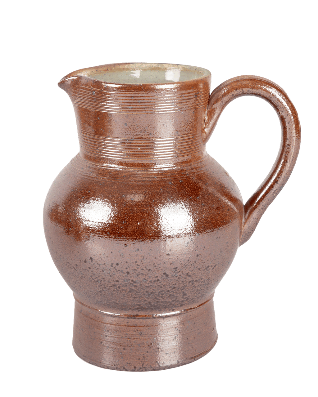 Back of a salt-glazed French pitcher showing dark speckling across the rounded belly on a green background