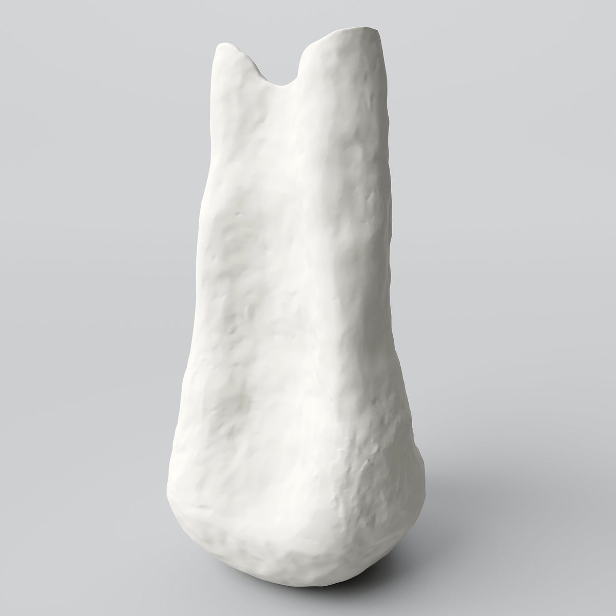 Slender white sculpted porcelain vase in three-quarter view showing its swelling base and notched rim