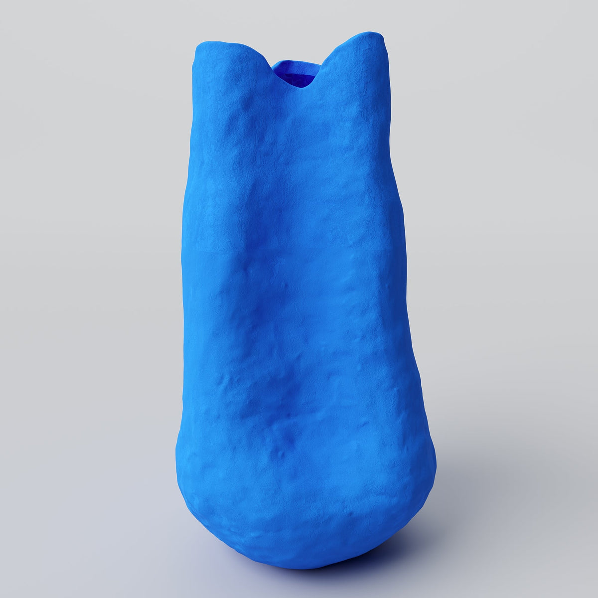 Tall Matte Blue Porcelain Vase styled on a wood table with linen in a modern Southwest room
