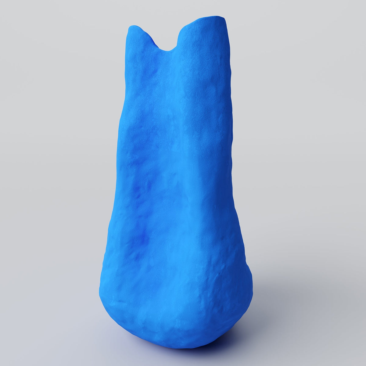 Tall Matte Blue Porcelain Vase shown in warm window light on an adobe toned shelf at home