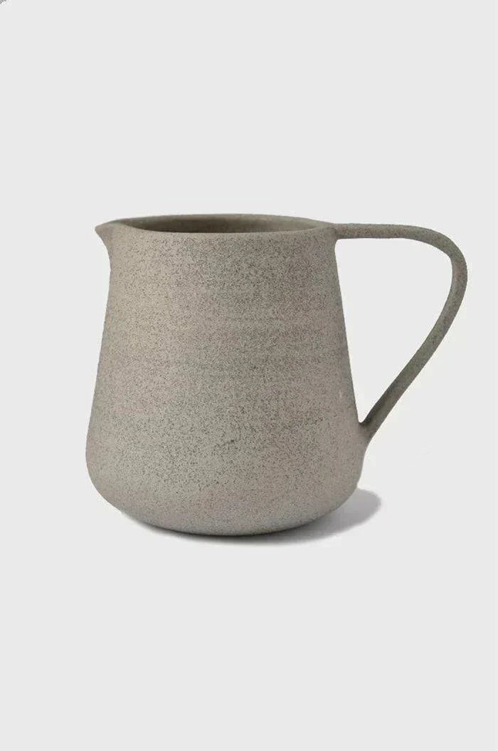 Concrete-Toned Stoneware Pitcher photographed on a bone white surface in soft natural light