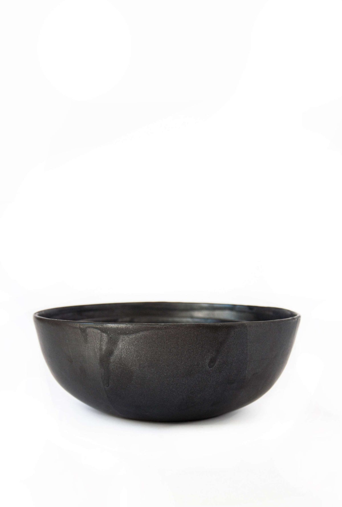 Single matte black stoneware salad serving bowl shown on a plain white background