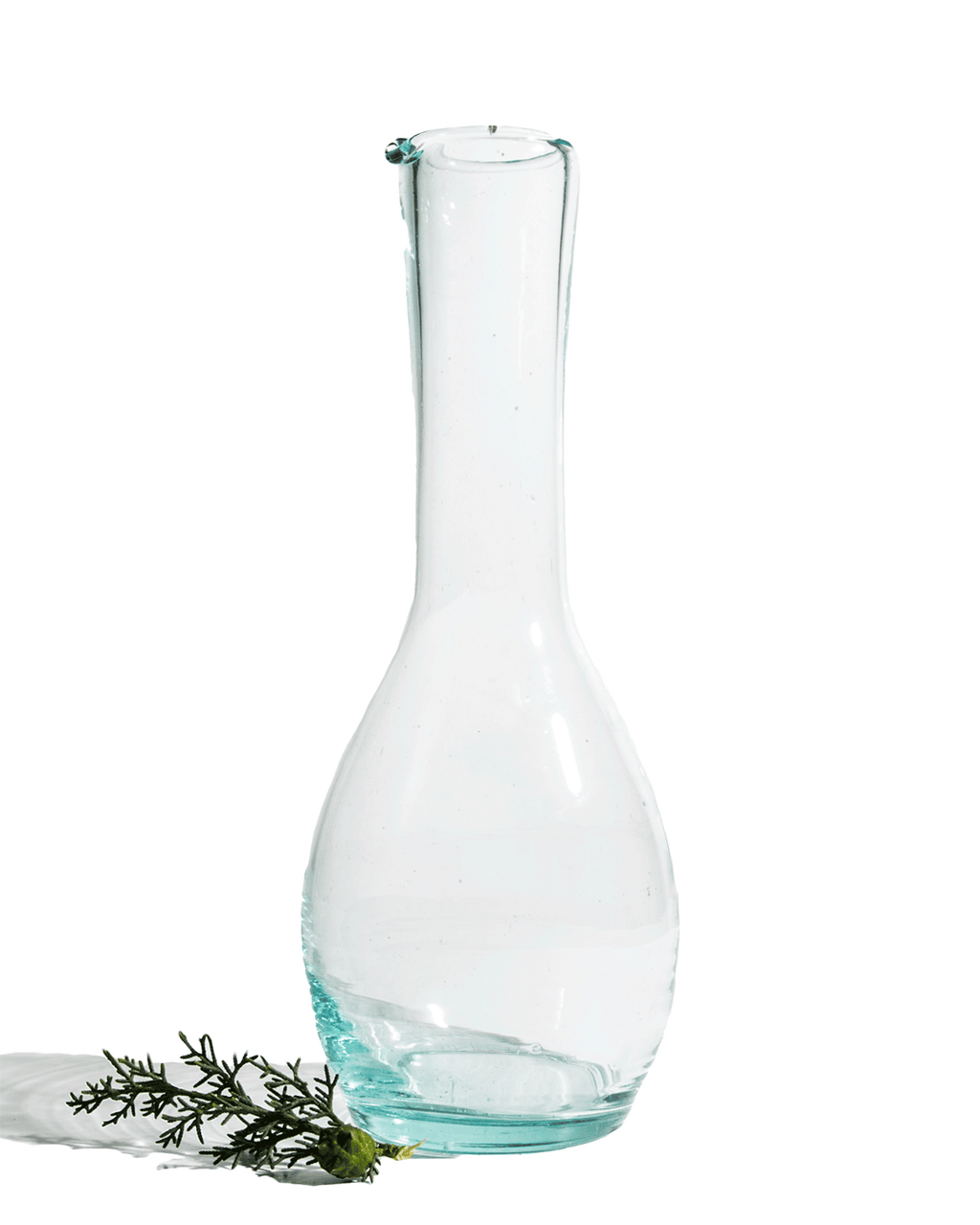Tall clear recycled glass bottle carafe with a slim neck shown on a deep green background