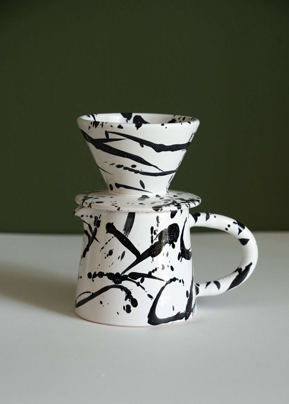 Splatter glazed pour-over set with the cone dripper on top and the pitcher handle to the right