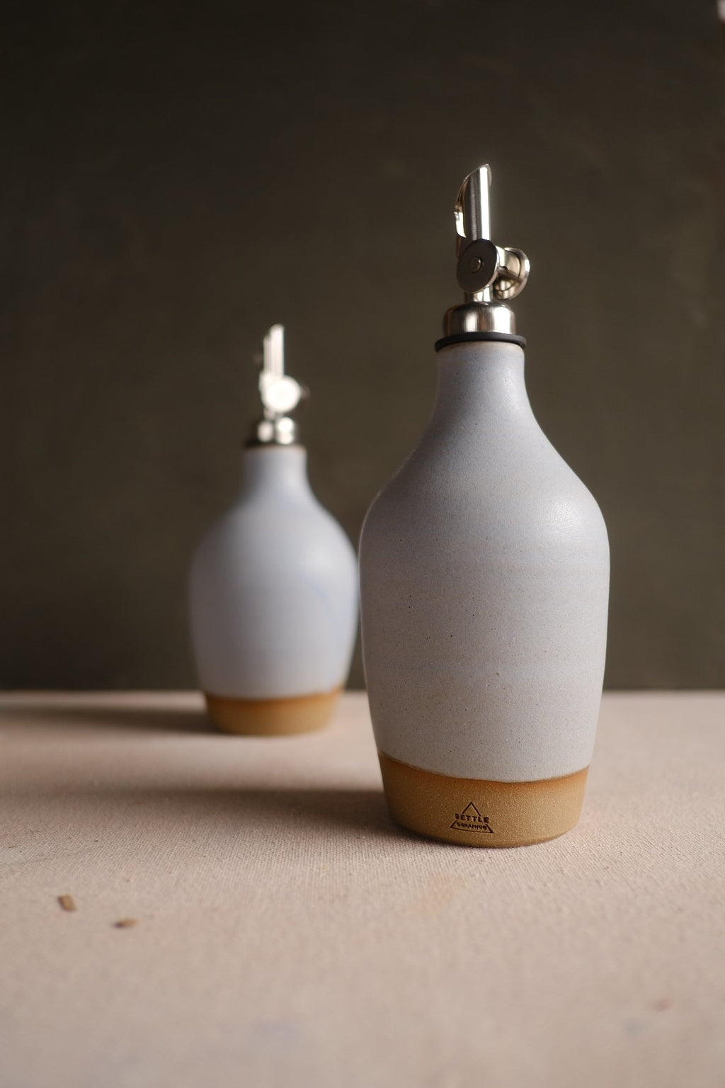 Hand-Thrown Stoneware Oil Bottle photographed on a bone white surface in soft natural light