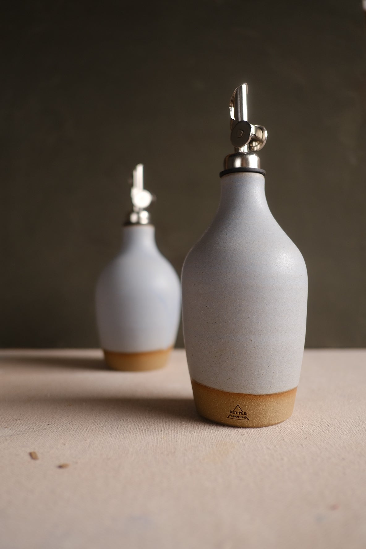 Hand-Thrown Stoneware Oil Bottle photographed on a bone white surface in soft natural light