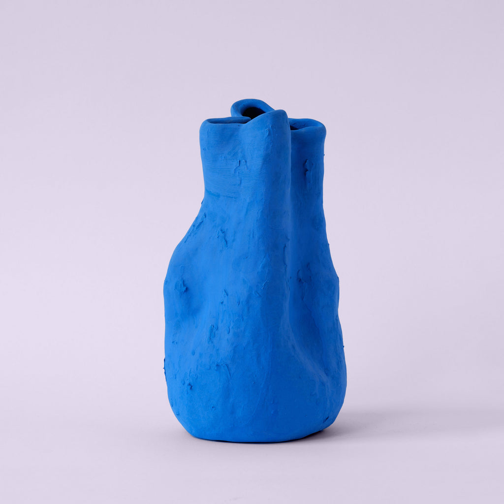 Sculpted Matte Blue Porcelain Vase photographed on a bone white surface in soft natural light