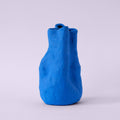 Sculpted Matte Blue Porcelain Vase photographed on a bone white surface in soft natural light