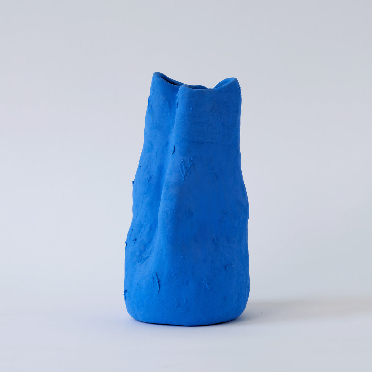Sculpted Matte Blue Porcelain Vase shown from a second angle against a pale neutral backdrop