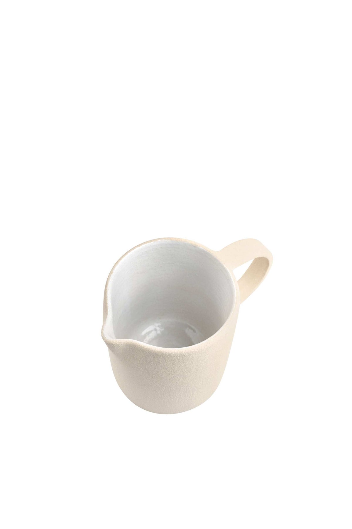Top view of the stoneware pitcher showing its white glazed interior and pouring lip on white