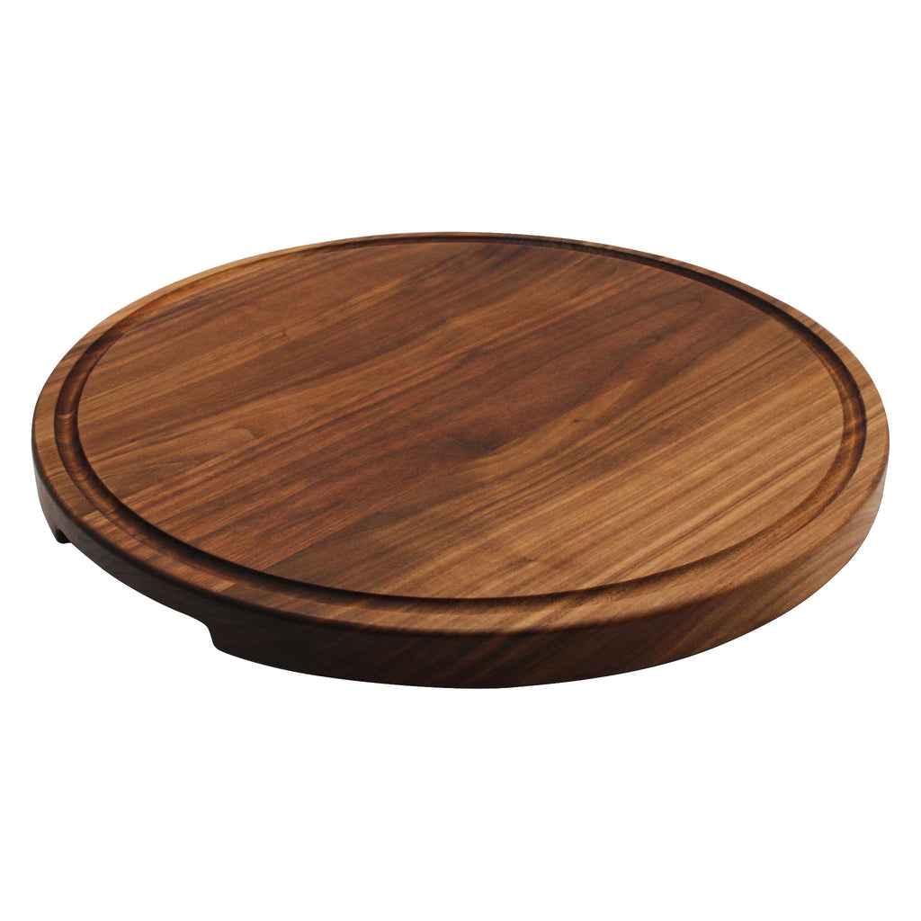 Thick round walnut cutting board with a juice groove, 18 in, low angled view showing the 1.25 inch edge