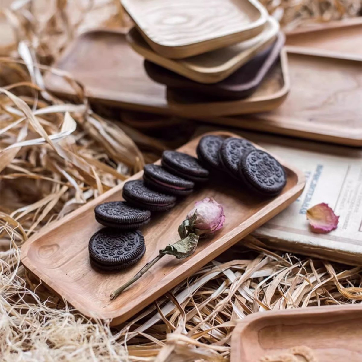 Medium cherry snack plate with a row of chocolate cookies and a dried rose on a bed of straw