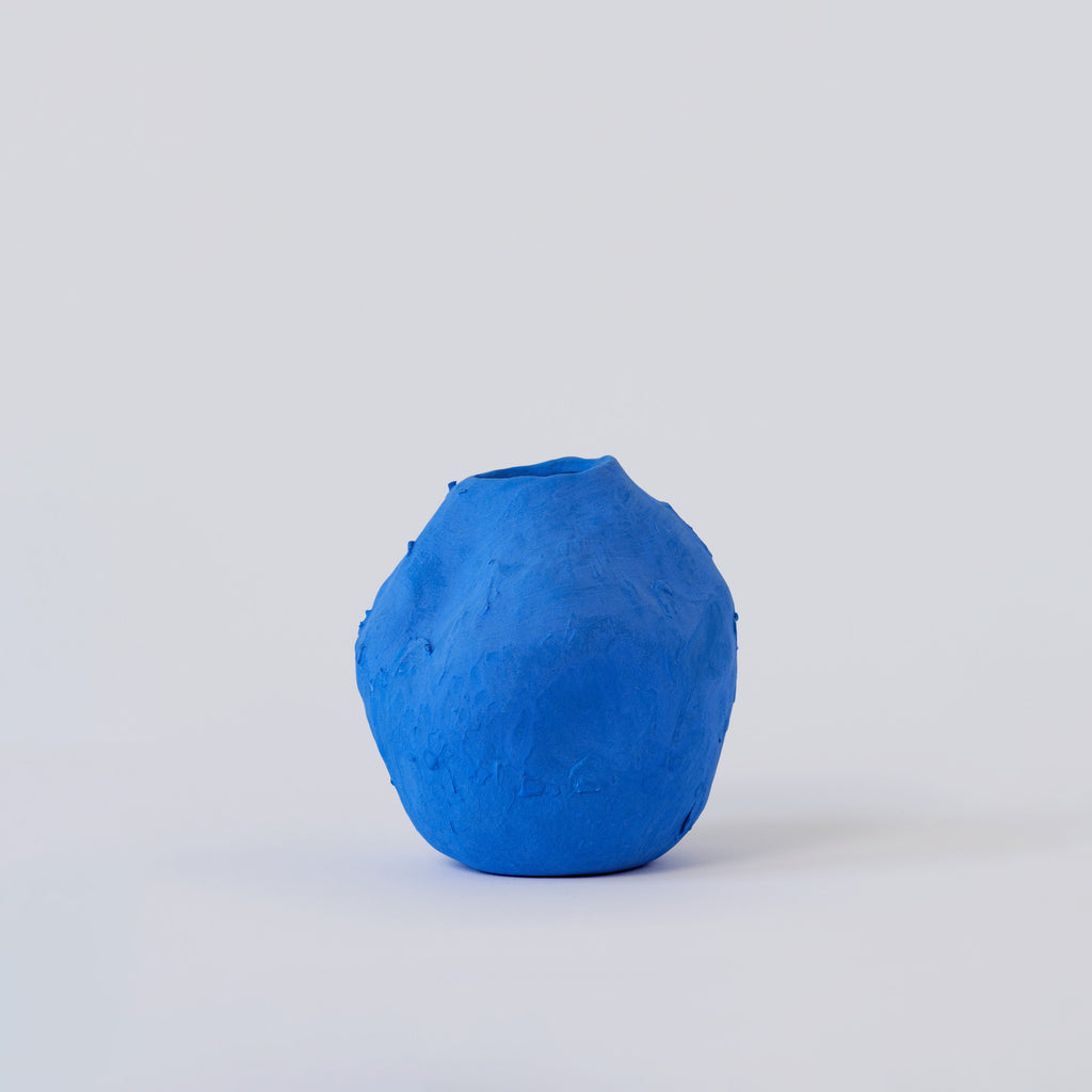 Matte Blue Porcelain Bud Vase shown from a second angle against a pale neutral backdrop