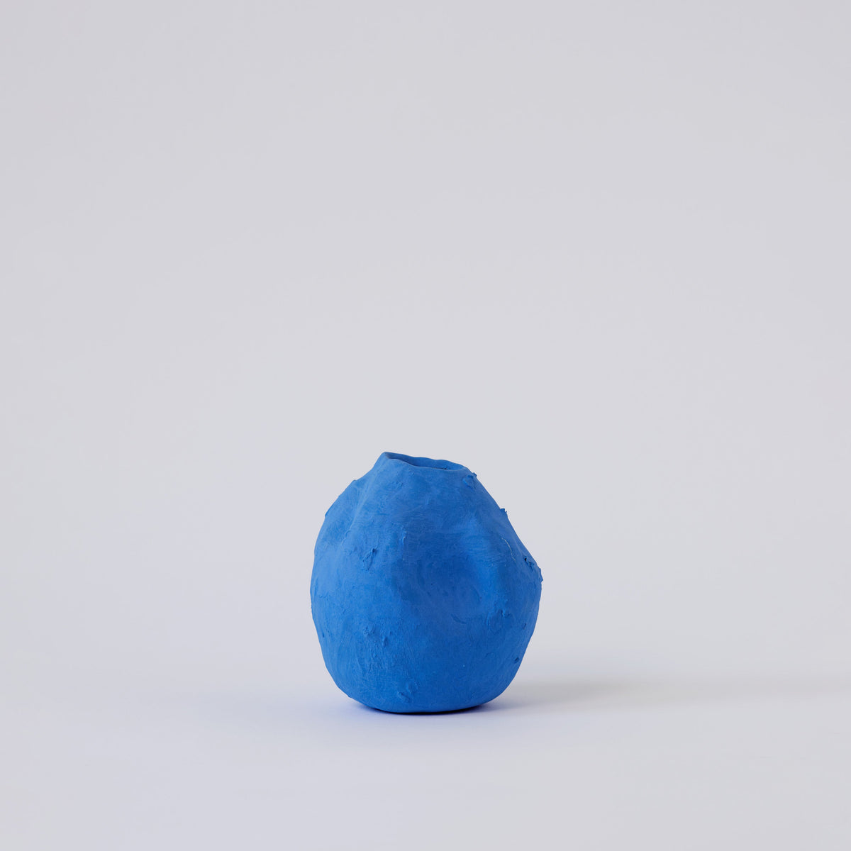 Matte Blue Porcelain Bud Vase styled on a wood table with linen in a modern Southwest room