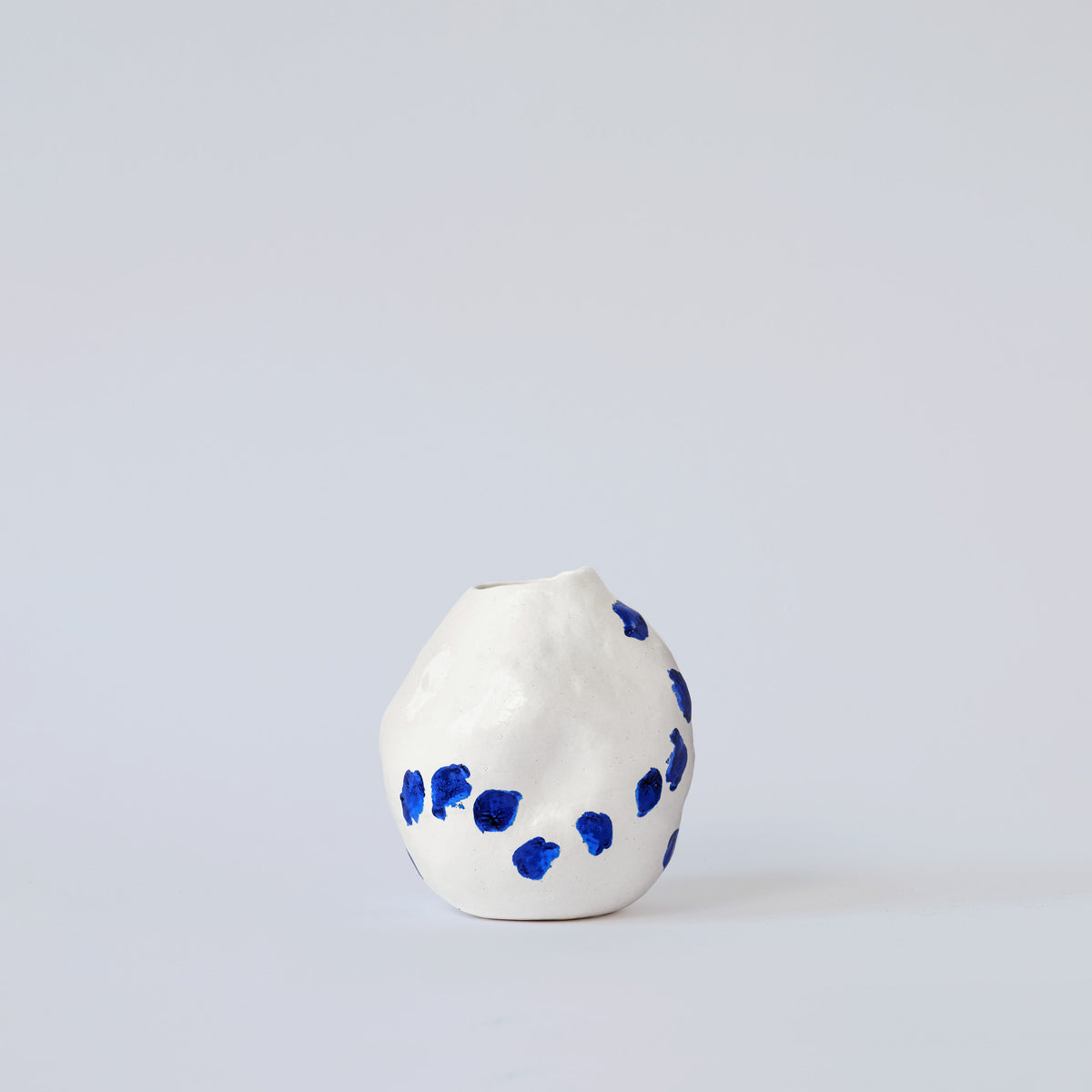 White and Blue Porcelain Bud Vase styled on a wood table with linen in a modern Southwest room