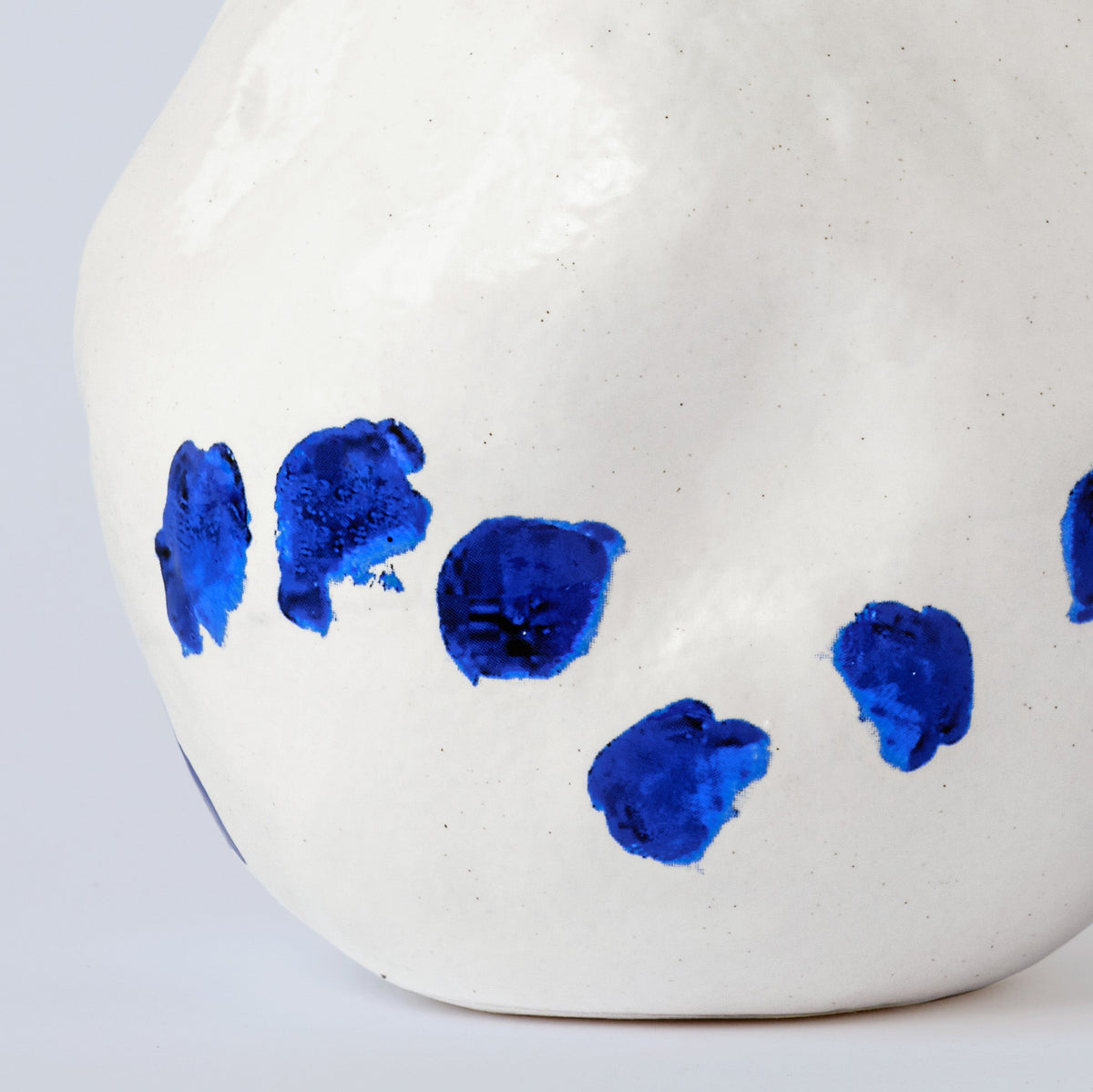 White and Blue Porcelain Bud Vase shown from a second angle against a pale neutral backdrop