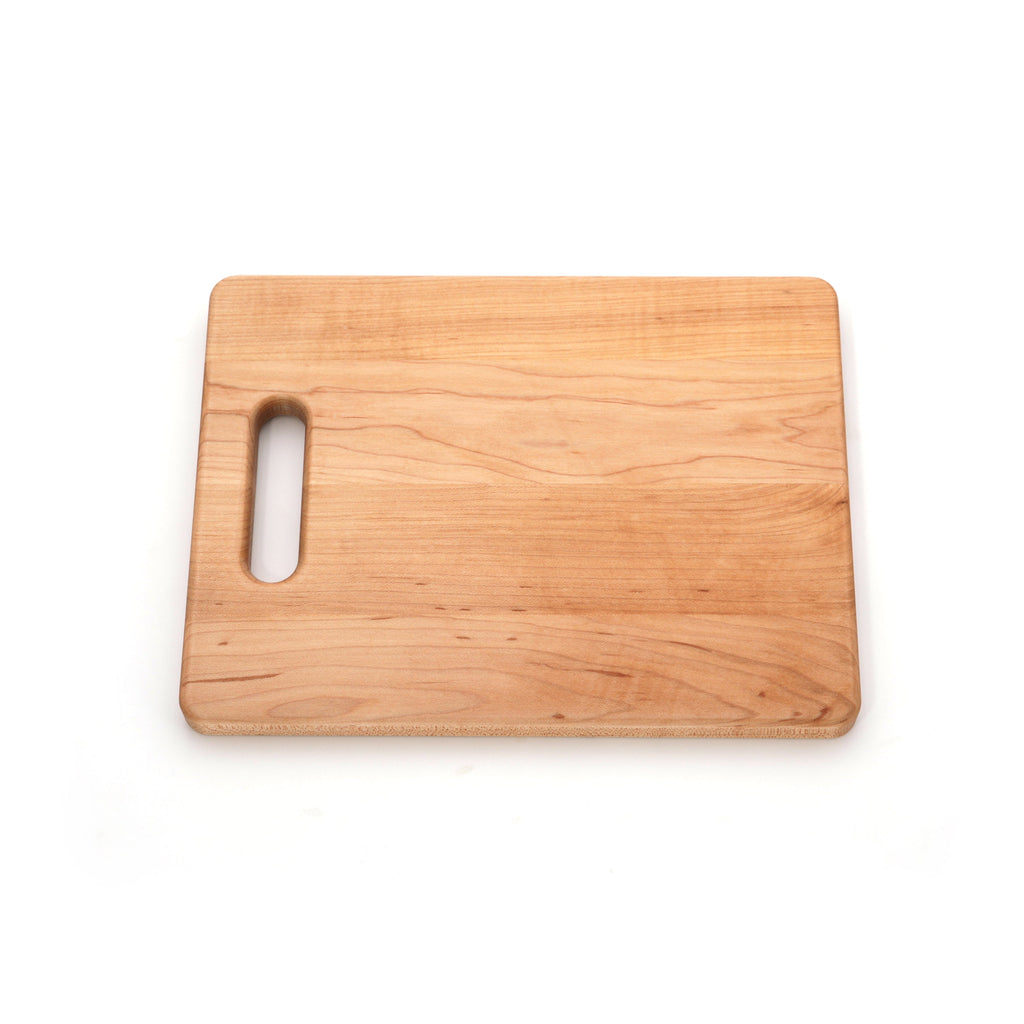 Maple single handle cutting board, 12 x 9 in, slightly angled view on white showing warm grain