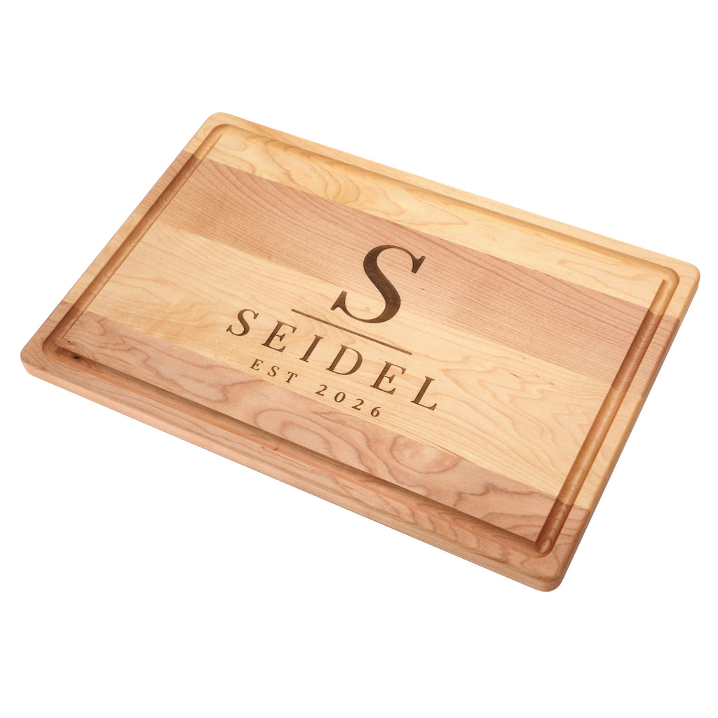 Maple cutting board with a juice groove, 18 x 12 in, angled view on white with a name and date carved in the center