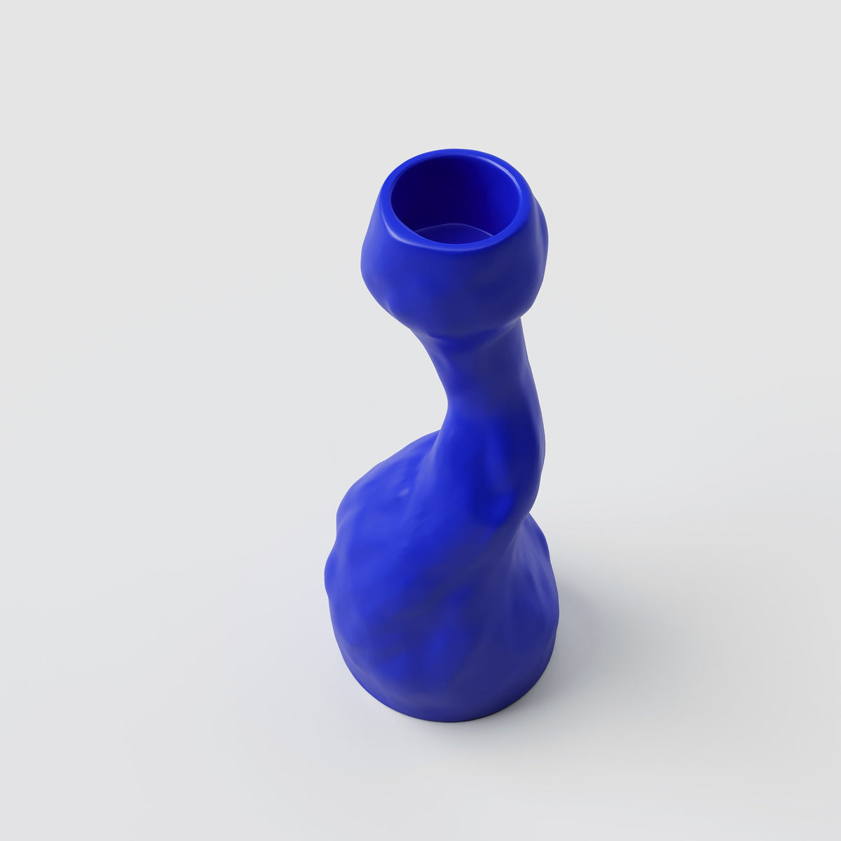 Curved Cobalt Porcelain Candle Holder shown from a second angle against a pale neutral backdrop