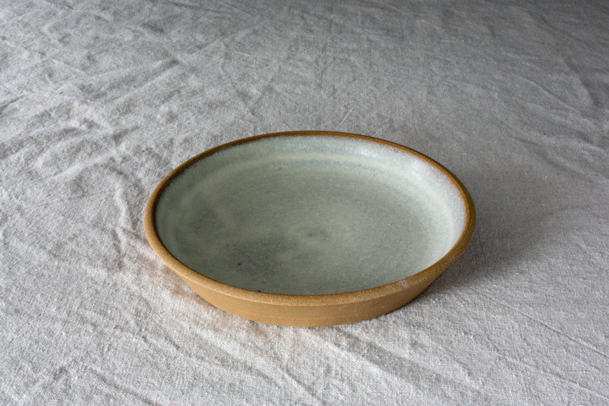 Fat Rim stoneware lunch plate in a pale speckled oat glaze with a bare clay rim on a white linen cloth