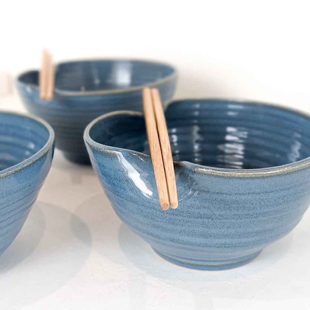 Three hand-thrown stoneware ramen bowls in sky blue glaze with throwing rings, chopsticks resting in the folds