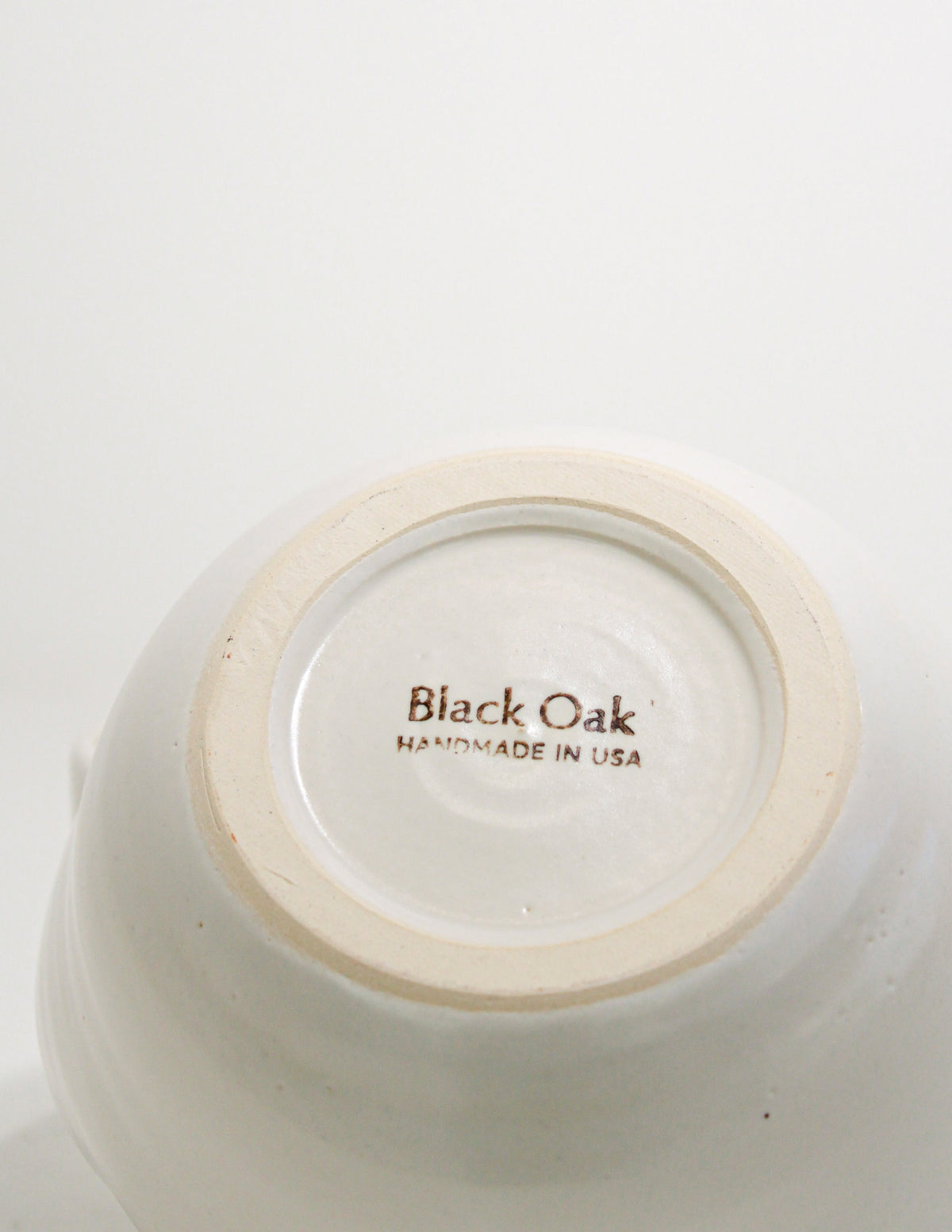 Underside of a white glazed stoneware ramen bowl showing the Black Oak handmade in USA stamp on the foot