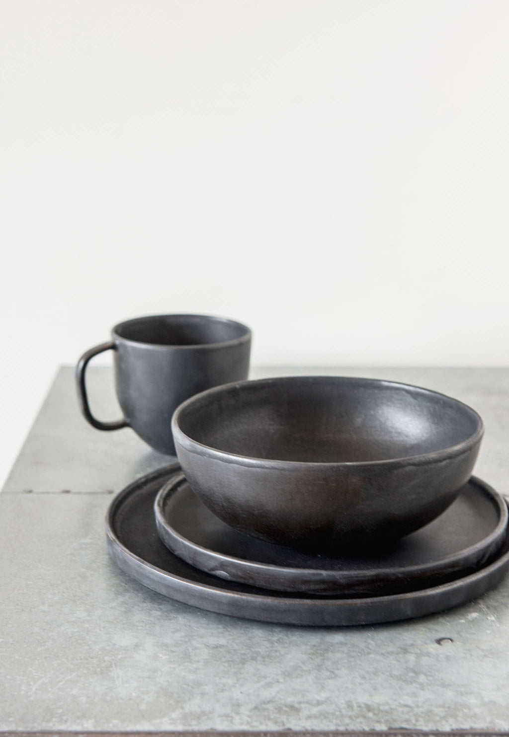 Matte Black Stoneware Mug styled on a wood table with linen in a modern Southwest room