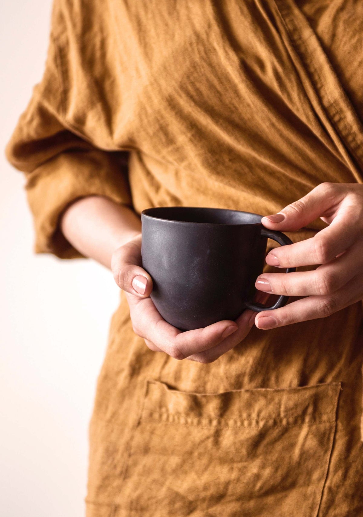 Matte Black Stoneware Mug photographed on a bone white surface in soft natural light