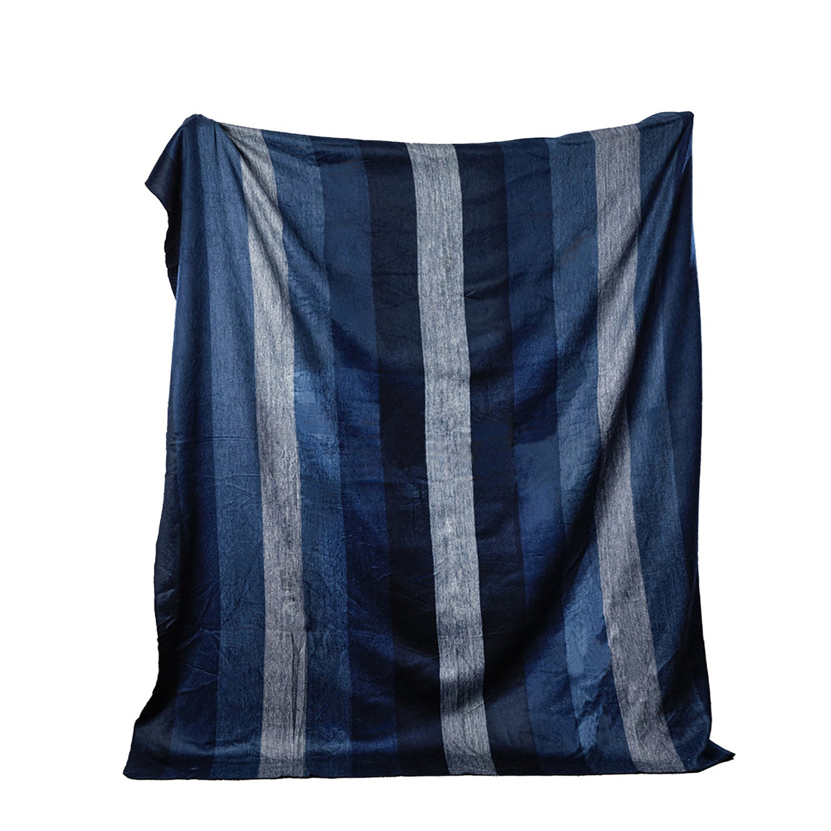 Alpaca throw in wide stripes of indigo, navy and gray-blue laid flat against a white background