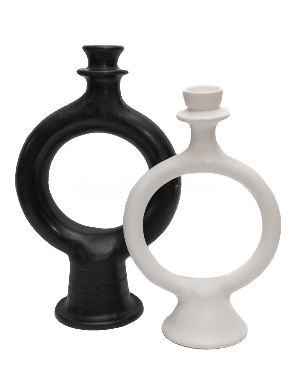 Black and white sculptural ring-shaped terracotta candle holders overlapping on a black background
