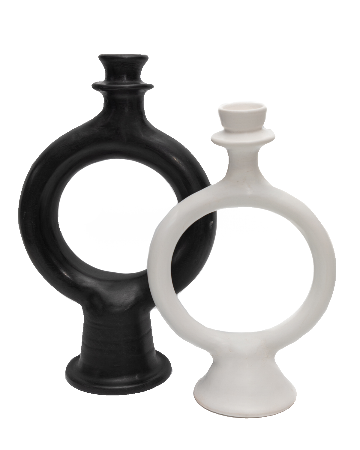 Black and white sculptural ring-shaped terracotta candle holders overlapping on a black background