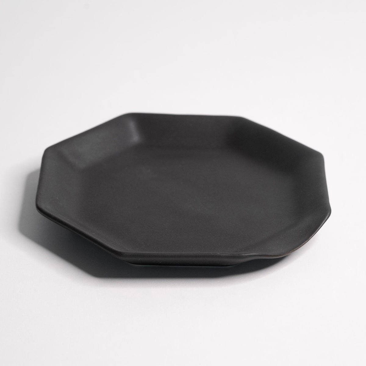 Octagonal Glazed Porcelain Spoon Rest placed on open kitchen shelving among neutral ceramics
