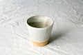 Short Hand-Thrown Stoneware Tumbler Cup photographed on a bone white surface in soft natural light