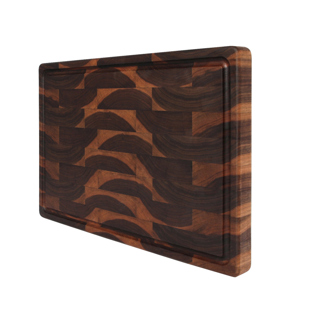 End grain walnut cutting board with a juice groove, 18 x 12 in, propped upright at an angle on white