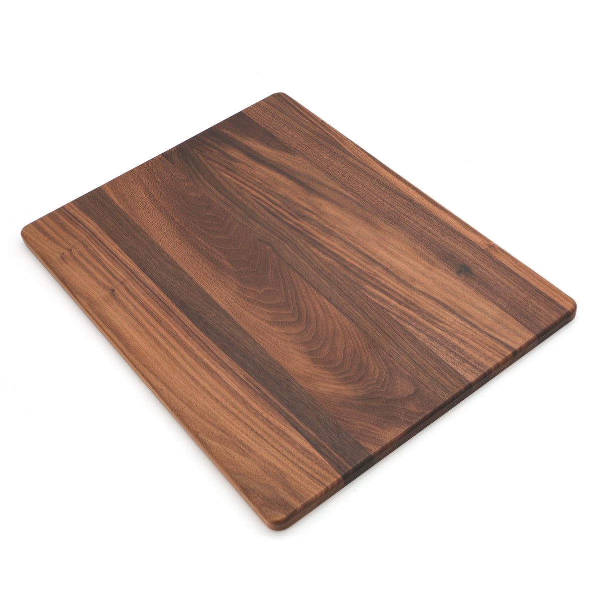 Extra large walnut cutting board, 24 x 18 in, lying at an angle on white with mixed dark and light grain