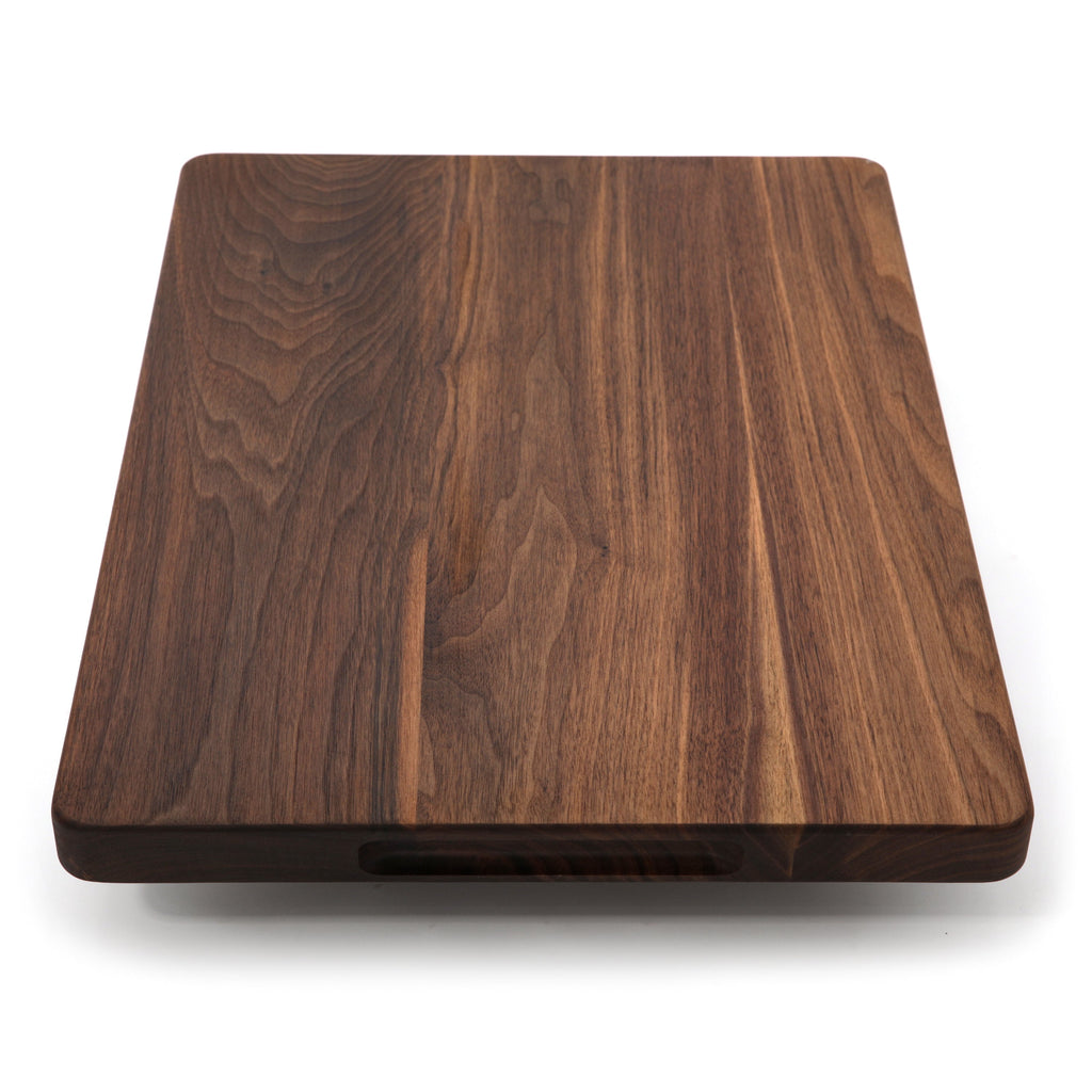 Thick walnut cutting board, 20 x 15 in, angled view with a pocket handle visible under the near edge