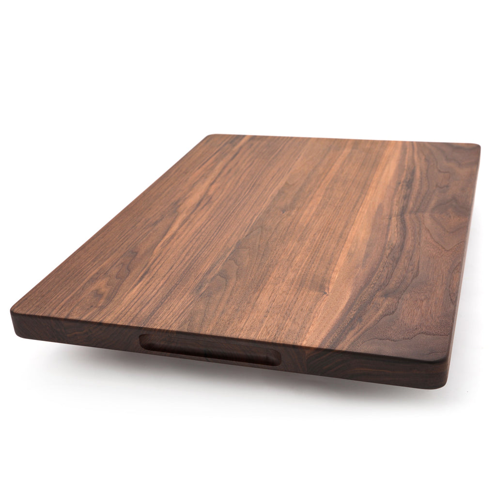 Extra large thick walnut cutting board, 24 x 18 in, angled view with a pocket handle cut under the edge