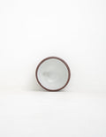 Hand-thrown stoneware coupe sauce bowl in white glaze tipped upright to show the interior and clay rim