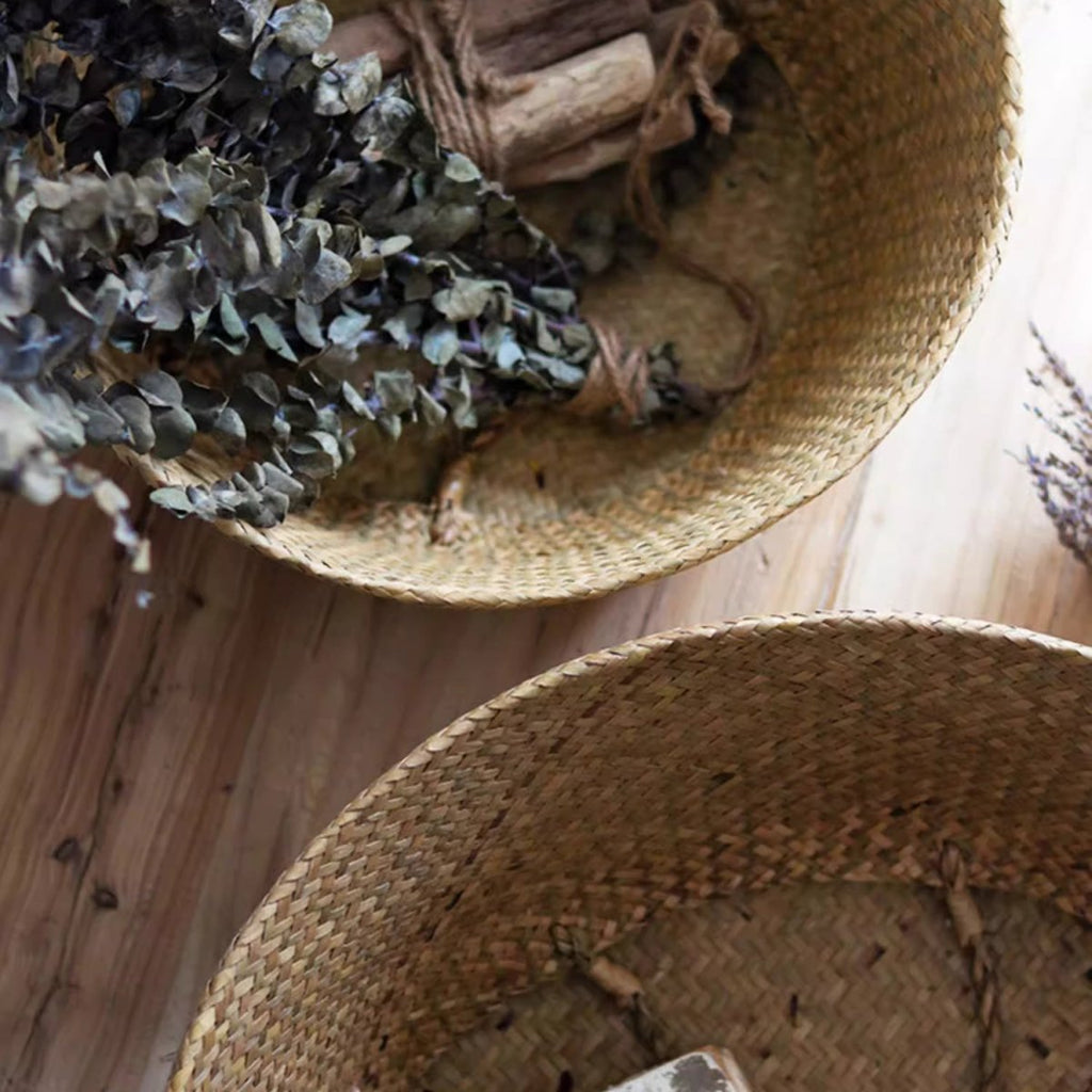 Close view inside woven seagrass belly baskets with dried eucalyptus, showing the tight flat weave