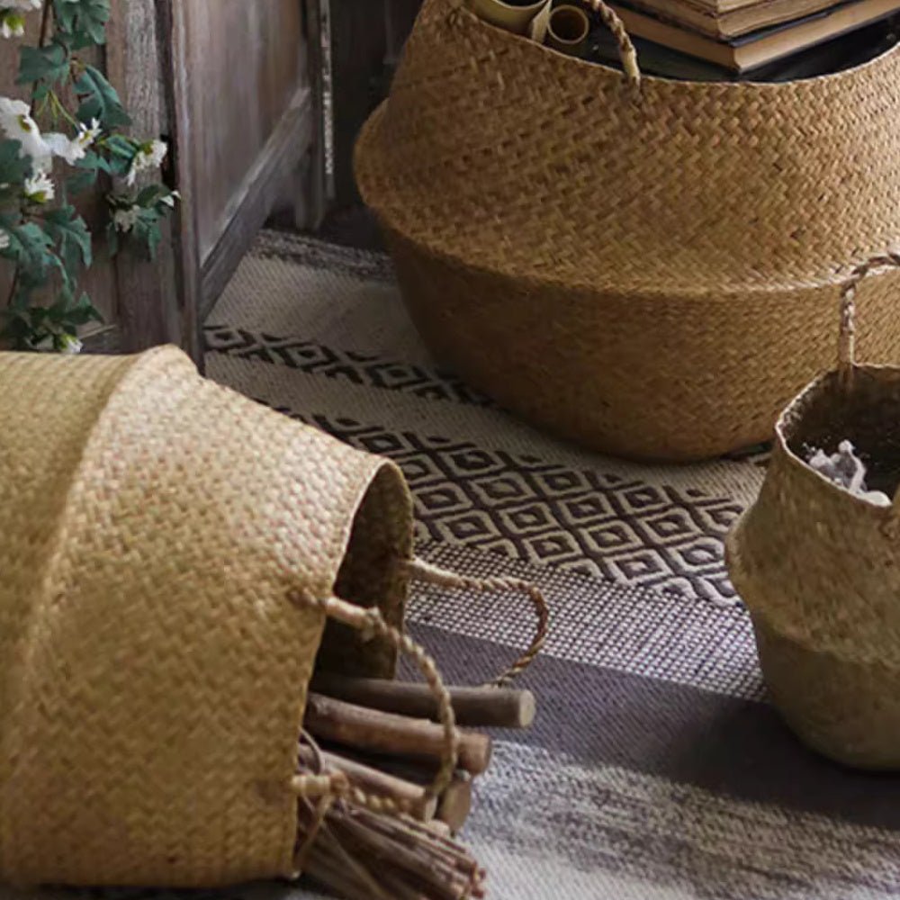 Large seagrass belly basket on a rug with a smaller one on its side filled with cut kindling