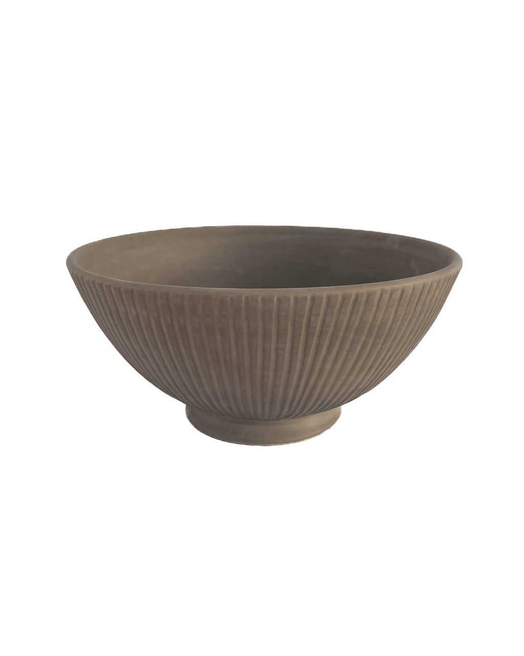 Large footed ceramic serving bowl in warm clay tone with carved vertical lines on a green background