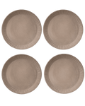 Four clay-toned ceramic dinner plates with hand-carved line rims, shown from above on a deep green ground