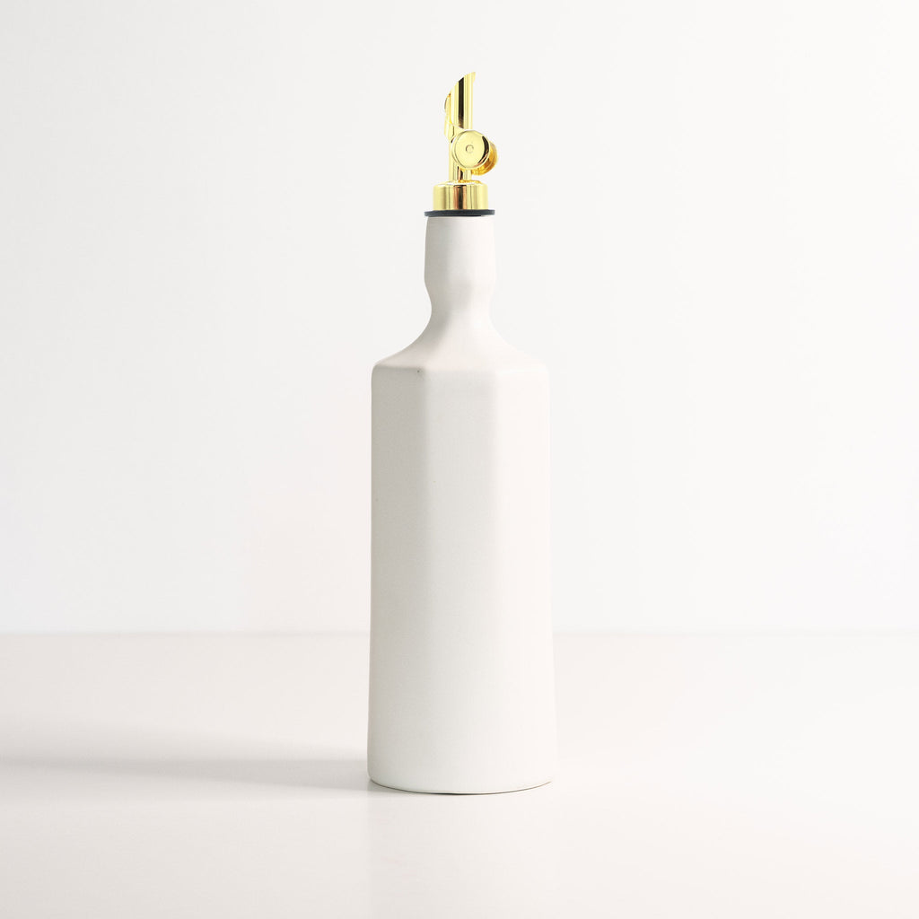 Porcelain Olive Oil Dispenser shown in warm window light on an adobe toned shelf at home